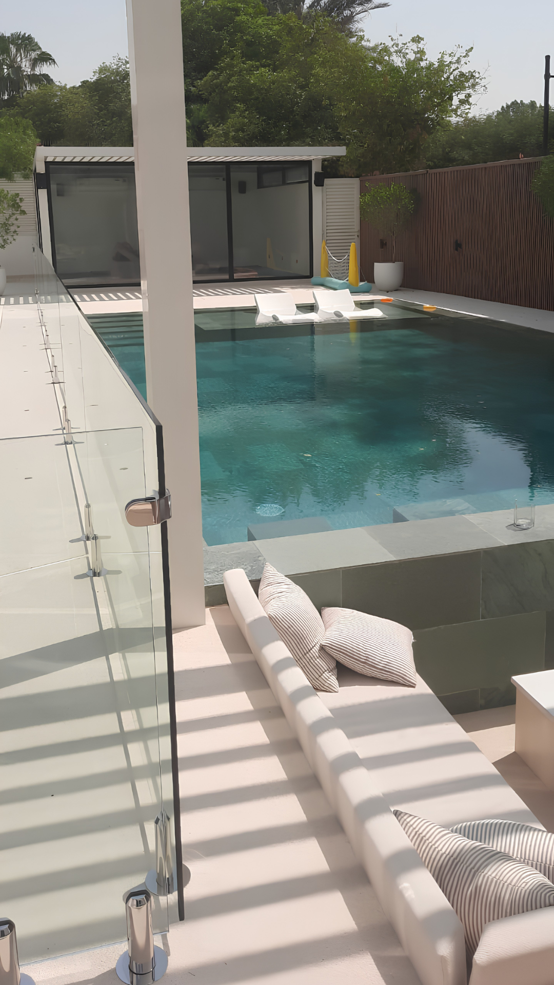 Luxury swimming pool protected by a clear frameless glass fence